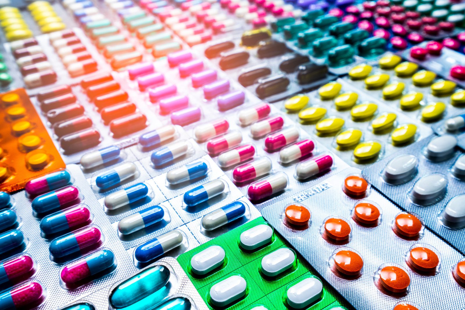 Rows of colored blister packs of tablets and capsules