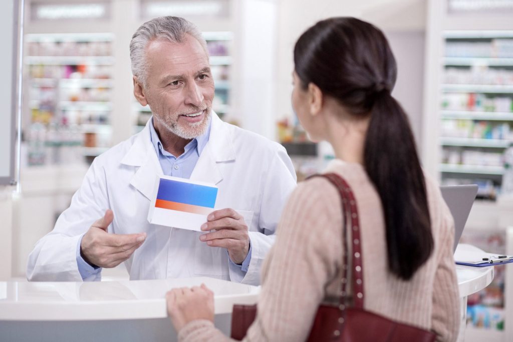 Pharmacist consulting with a patient at the counter
