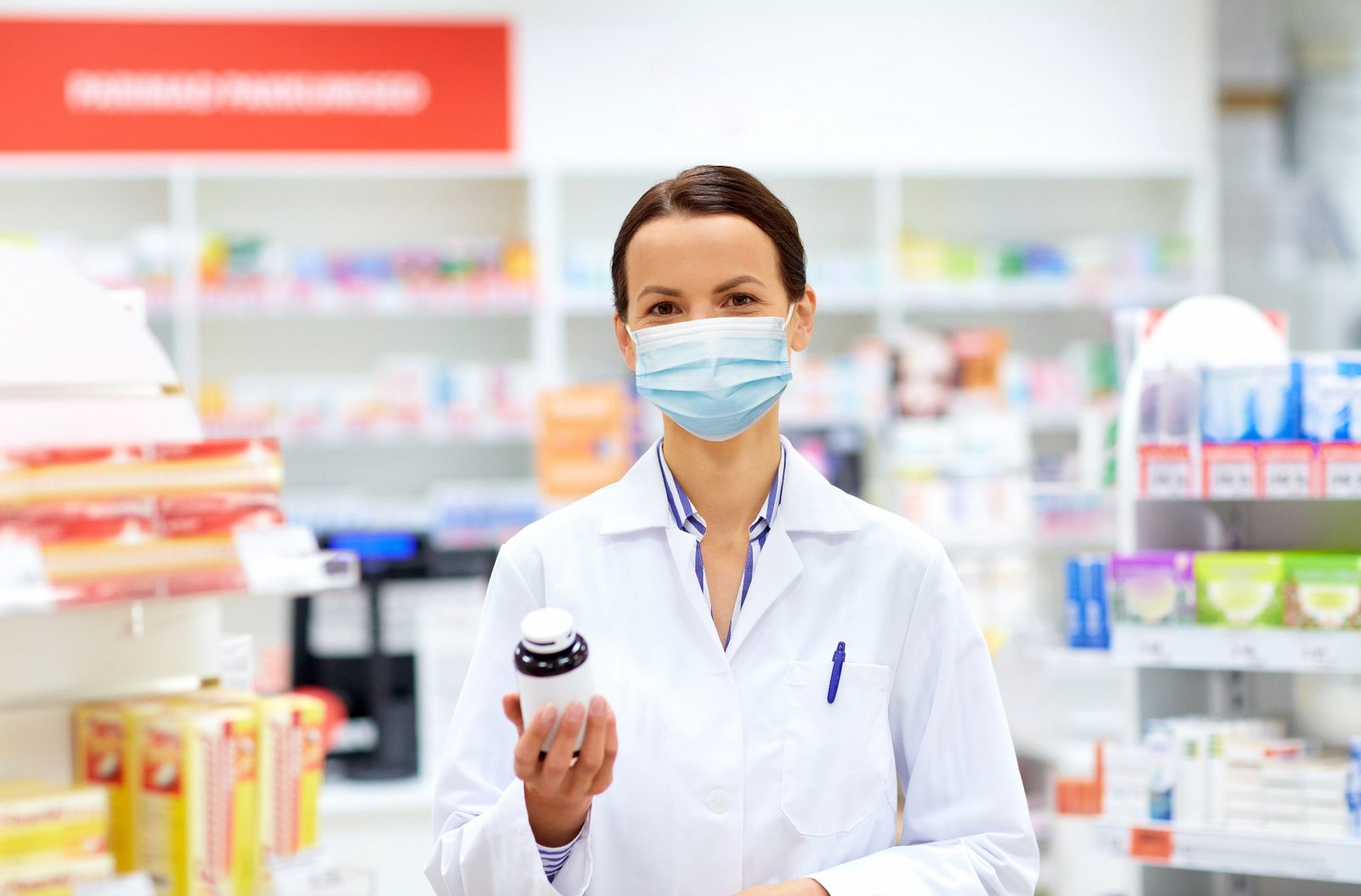 A pharmacist holding a medication container in the pharmacy