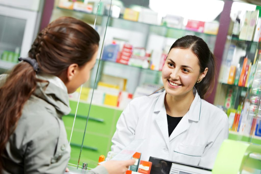 Pharmacy staff helping a customer at the counter